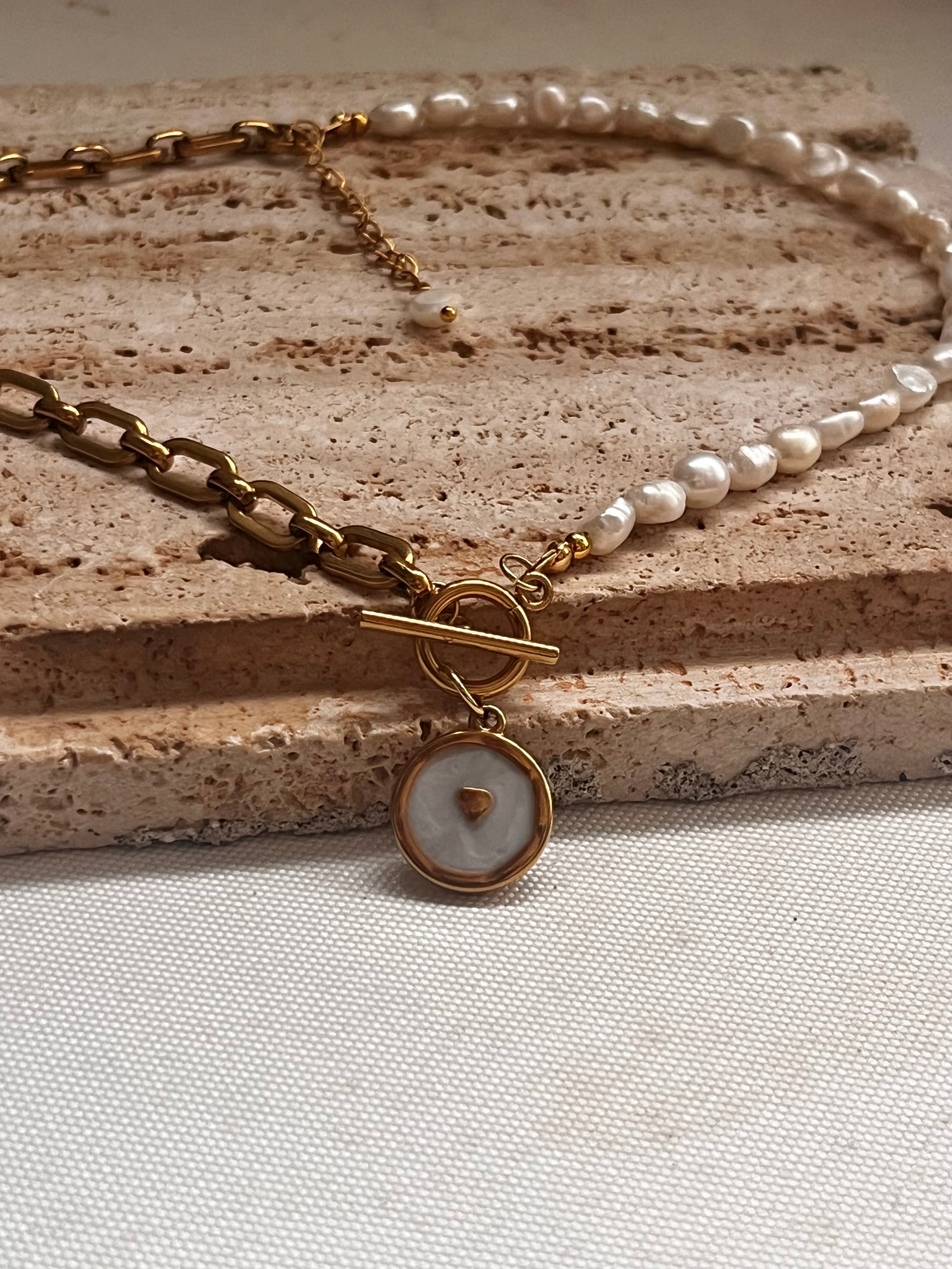Handcrafted pearl necklace featuring a gold T-bar toggle clasp and a mother of pearl heart pendant.